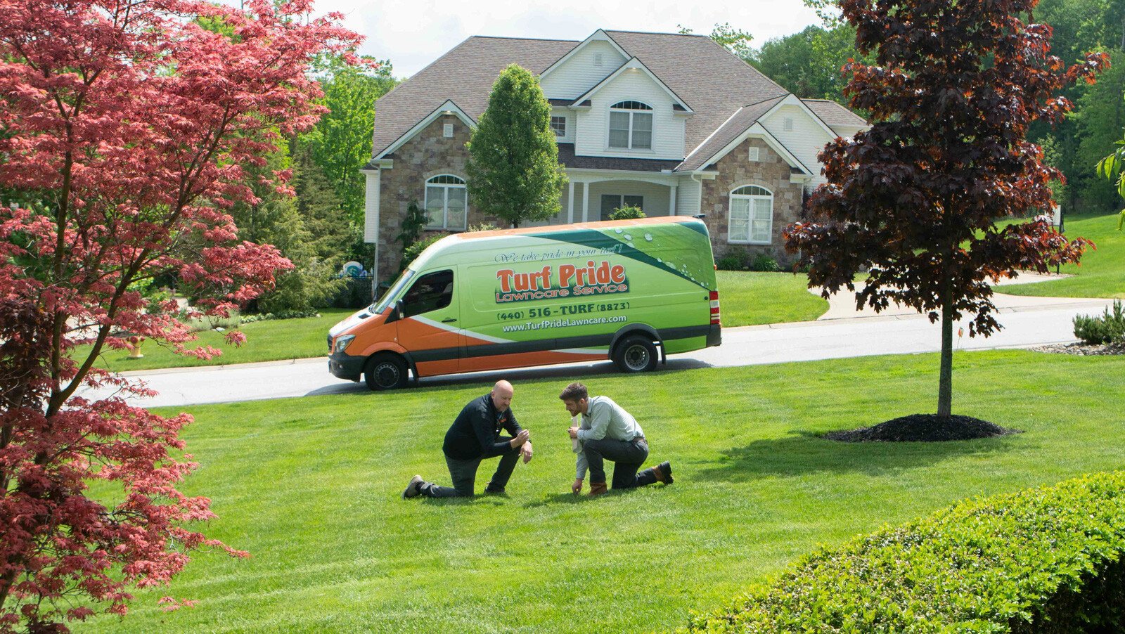 Technicians looks closely at lawn to see condition