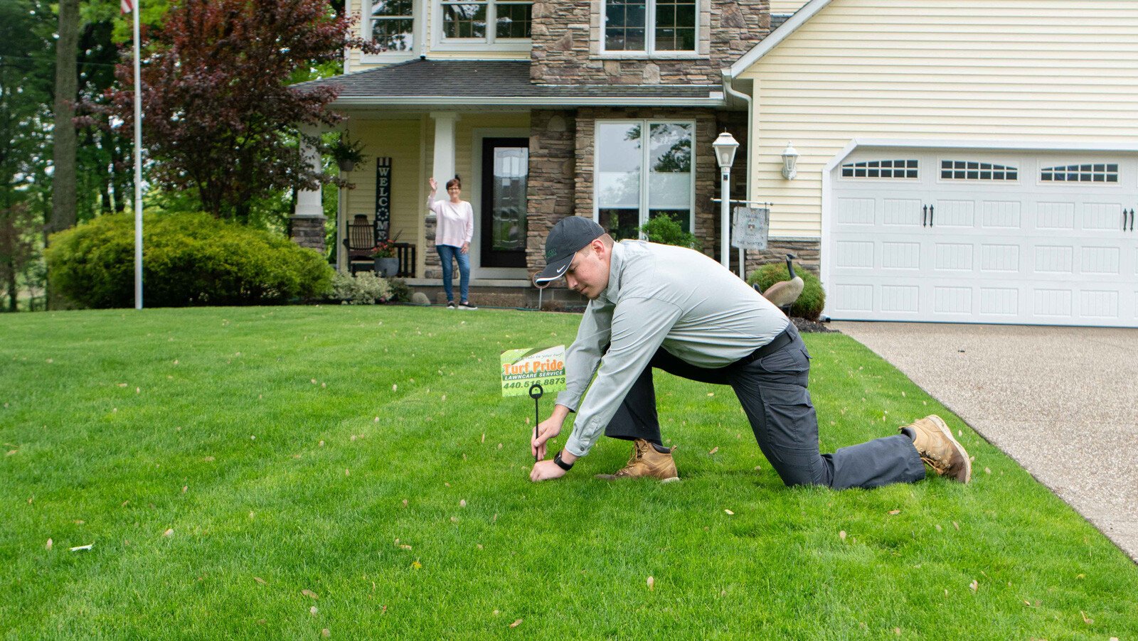 technician placing flag on green lawn