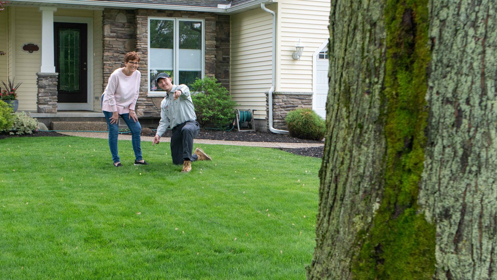 technician with customer showing lawn