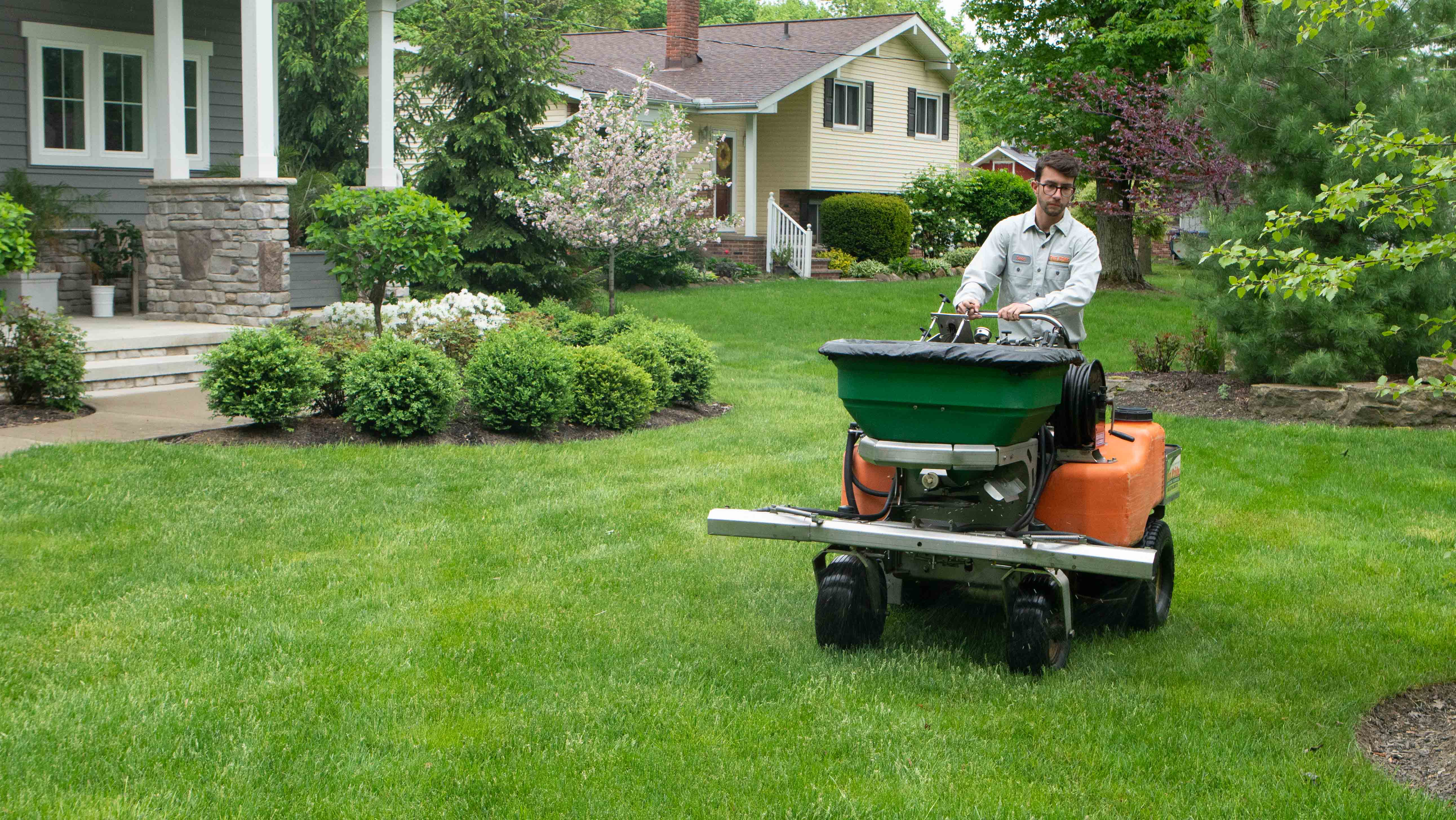 Lawn technician fertilizing grass